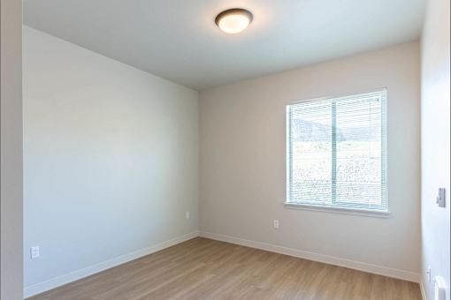 A room with a window and wooden flooring.