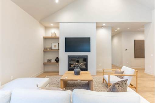A living room with a fireplace and a flat screen TV.
