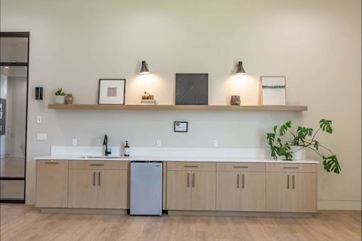 A kitchen with a white countertop and wooden cabinets.
