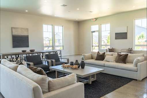 A living room with a white couch, black chairs, and a coffee table.