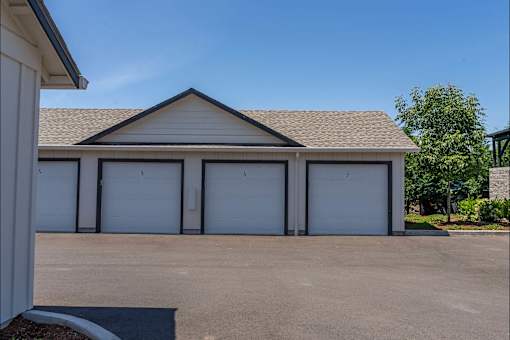 A building with a brown roof and white garage doors.