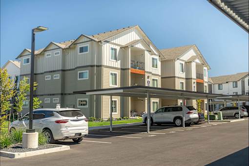 A row of townhouses with cars parked in front at Cascade Place Apartment Homes, Molalla, 97038