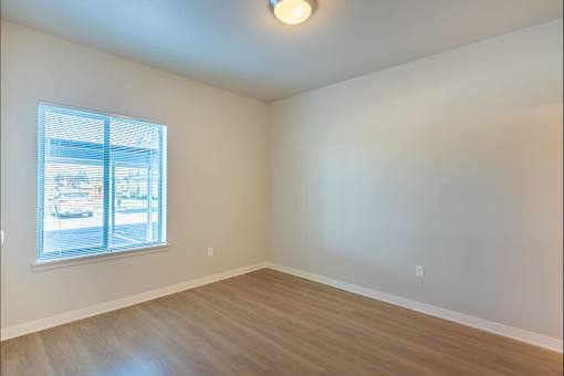 A room with a window and wooden flooring at Cascade Place Apartment Homes, Molalla, OR