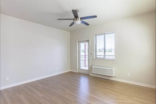 A room with a ceiling fan and a window with a view of a balcony at Cascade Place Apartment Homes, Molalla