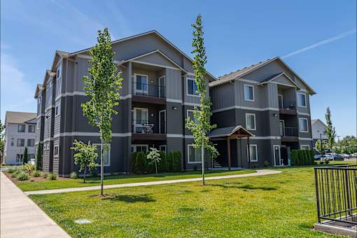 A modern apartment building with a well-maintained lawn in front at Northplace Apartment Homes, Salem, OR