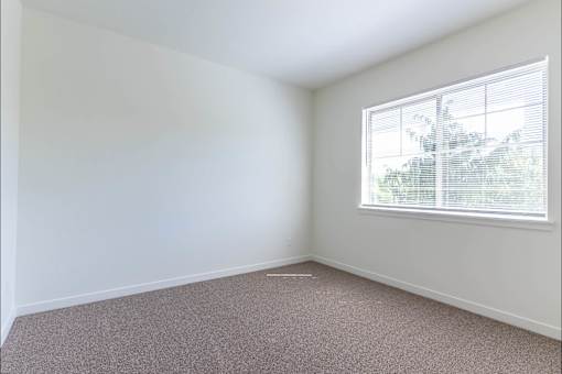 A room with a window and carpeted floor at Riverplace Apartment Homes, Independence, OR, 97351