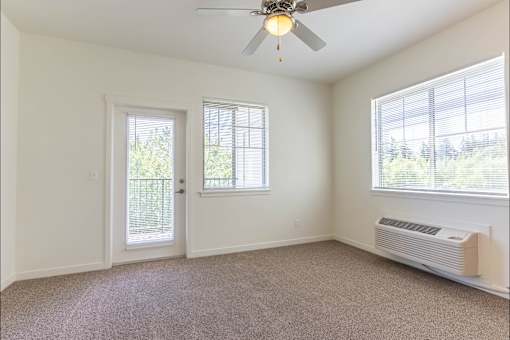 A room with a ceiling fan and a window with blinds at Riverplace Apartment Homes, Independence, OR