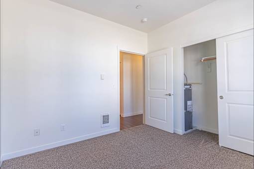 A white room with a door and a small cabinet at Riverplace Apartment Homes, Independence, OR, 97351