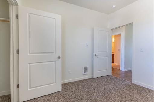 A white door is open to a hallway at Riverplace Apartment Homes, Independence, 97351