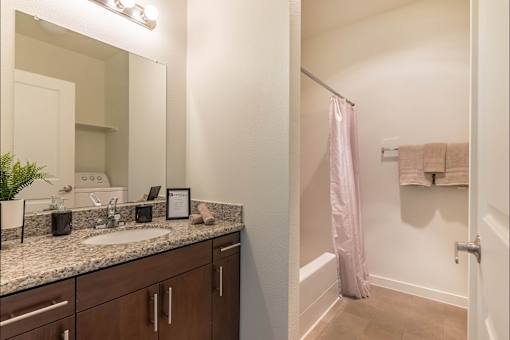 A bathroom with a sink, mirror, and towel rack at Riverplace Apartment Homes, Independence, 97351