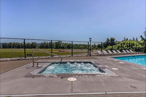 A pool with a hot tub in the middle of it at Riverplace Apartment Homes, Independence