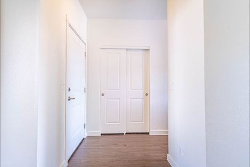 A white door is in the middle of a hallway at Riverplace Apartment Homes, Oregon, 97351
