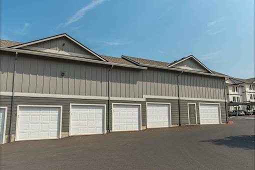 A large industrial building with grey walls and white garage doors at Sandyplace Apartment Homes, Sandy, OR