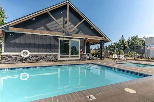 A pool with a house in the background at Silverplace Apartment Homes, Silverton