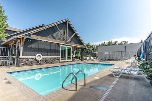 A pool with a slide and a house behind it at Silverplace Apartment Homes, Silverton, 97381