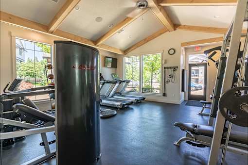 A gym with a row of treadmills and a weight rack at Silverplace Apartment Homes, Silverton, OR