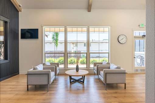 A living room with a large window and a flat screen TV mounted on the wall. at St Helens Place Apartment Homes, St Helens, OR, 97051