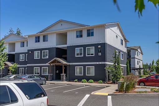 A large, modern building with a parking lot in front at St Helens Place Apartment Homes, St Helens, OR, 97051
