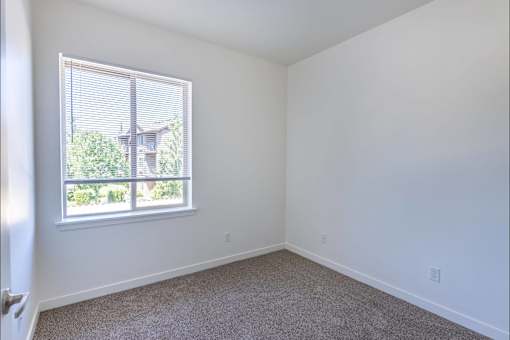 A room with a window and a carpeted floor at Stoneplace Apartment Homes, Oregon, 97038