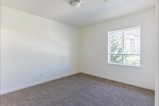 A room with a carpeted floor and a window at Stoneplace Apartment Homes, Oregon