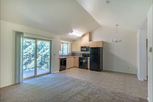 A spacious living room with a kitchen area in the background at Stoneplace Apartment Homes, Molalla