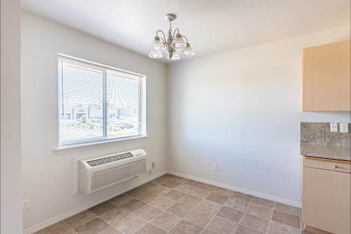 A room with a window, tiled floor, and a chandelier at Stoneplace Apartment Homes, Molalla, Oregon