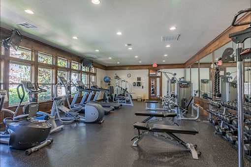 A spacious gym with a variety of equipment including treadmills, weights, and exercise machines at Stoneplace Apartment Homes, Molalla, 97038