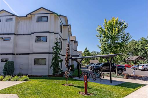 A white apartment building with a green lawn in front at Timberridge Place Apartment Homes, Albany