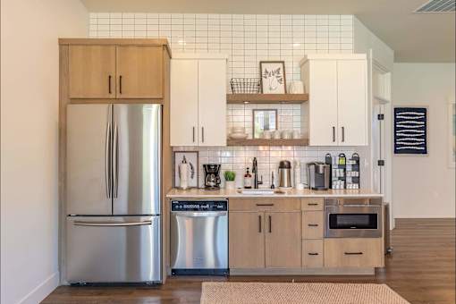 A kitchen with a refrigerator, cabinets, and a tiled backsplash at Timberridge Place Apartment Homes, Oregon, 97322