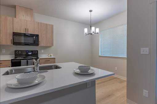 A kitchen with a sink, microwave, and oven at Woodburn Place Apartment Homes, Oregon
