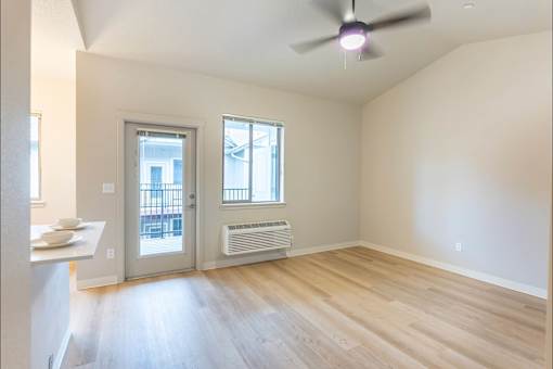A room with a ceiling fan and a window with a balcony at Woodburn Place Apartment Homes, Woodburn