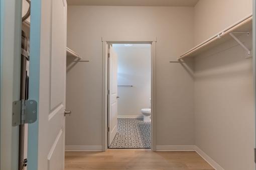 A white doorway leads to a bathroom with a toilet and a tiled floor at Woodburn Place Apartment Homes, Woodburn, OR