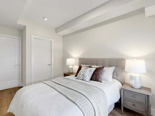 A bedroom with a large bed and two lamps.