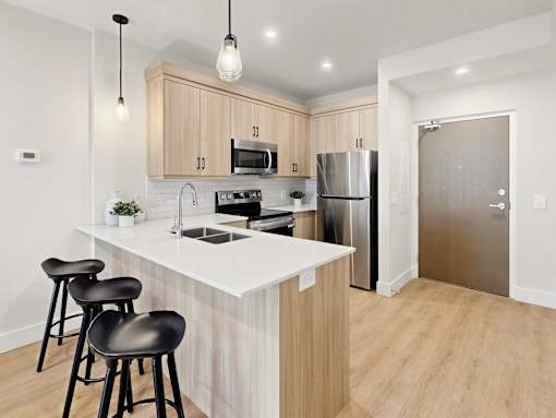 A kitchen with a white countertop and wooden cabinets.