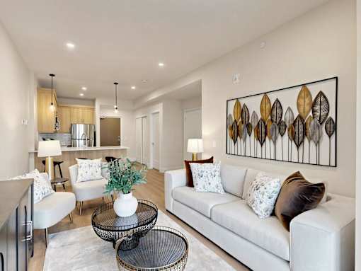 A modern living room with a white sofa and a large abstract painting on the wall.