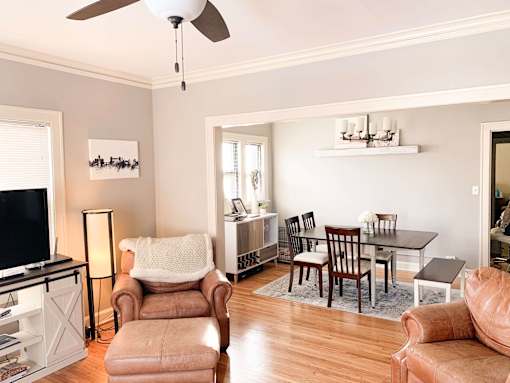 A living room with a brown chair and a brown ottoman.