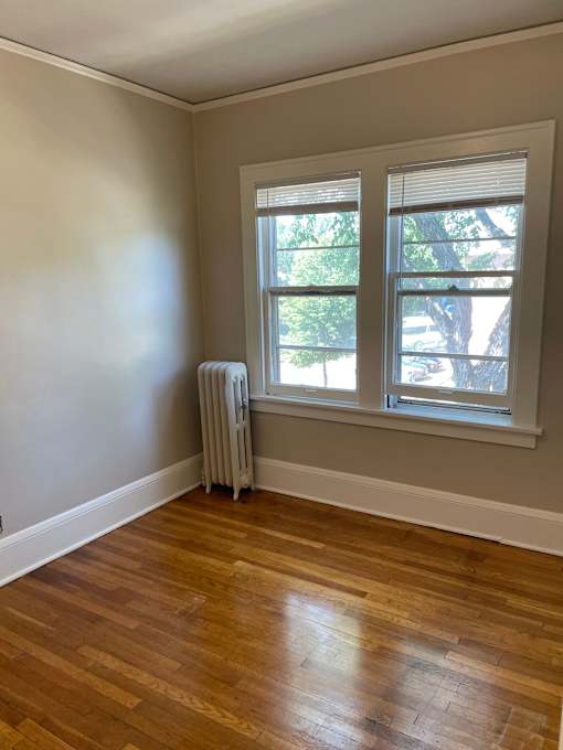 A room with a window and a radiator on the wall.