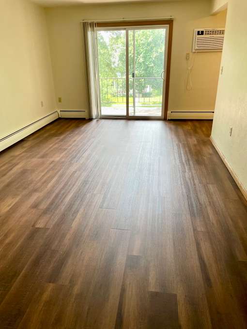 Sunny, west-facing living room with patio door to private balcony.