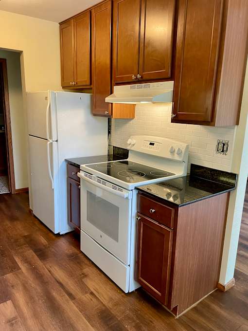 Kitchen with updated cabinets, granite countertops, and dishwasher.