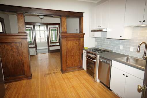 Updated kitchen with custom cabinets, decorative tiled backsplash and stainless steel appliances, including dishwasher.