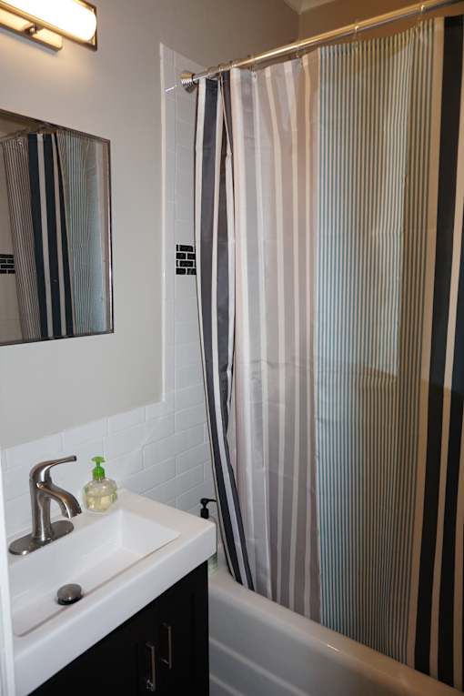 Updated bathroom with ceramic tiled shower/walls, and porcelain tile floor.