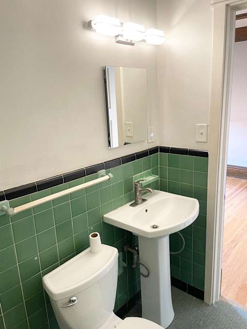 Vintage deco-tiled bathroom with updated fixtures.