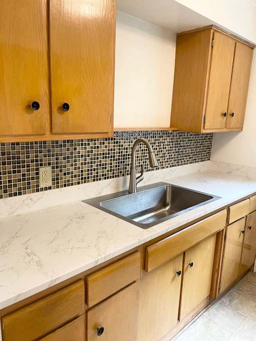 A kitchen with wooden cabinets and a sink.