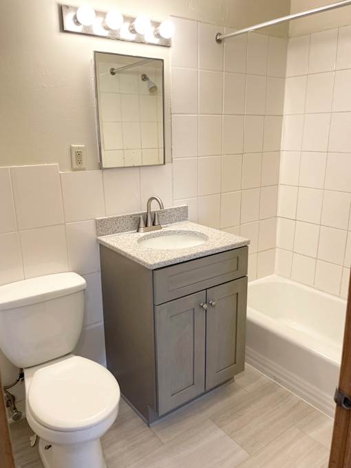 A white toilet sits next to a sink in a small bathroom.