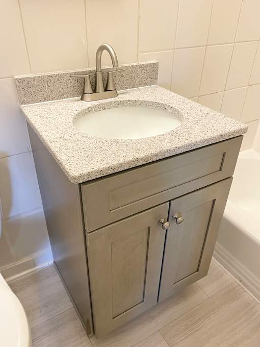 A bathroom sink with a granite countertop and a silver faucet.