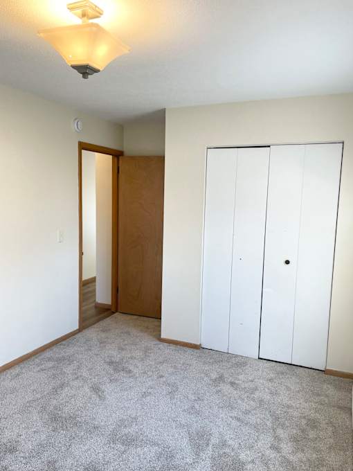 A room with a carpeted floor and a white wall.
