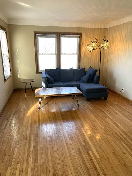 Corner living room with original hardwood floors and coved ceilings..