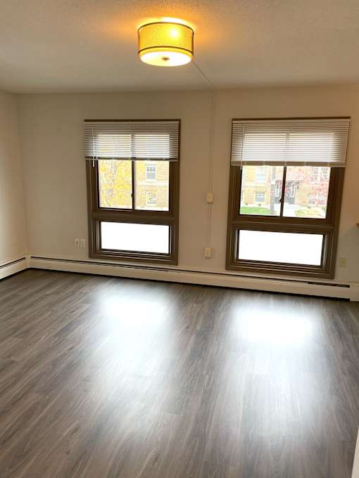 A room with two windows and a light on the ceiling.