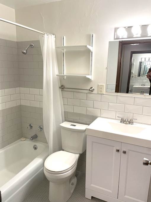 A white bathroom with a toilet, sink, and bathtub.