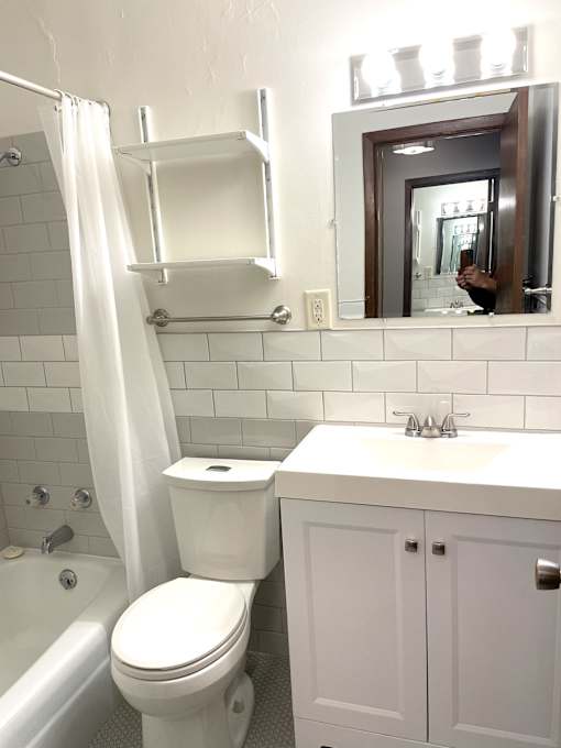 A white toilet in a bathroom with a white cabinet and a white sink.